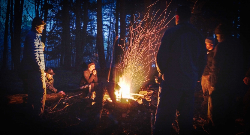 a group of veterans stand around a fire on an outward bound veterans expedition 